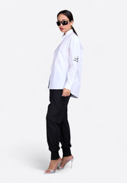 Model wearing logo-embossed off-white shirt, side pose – East Vibe